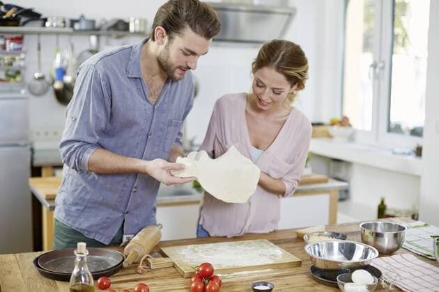 Couple preparing pizza dough in kitchen model released Symbolfoto property released  FMKF002363