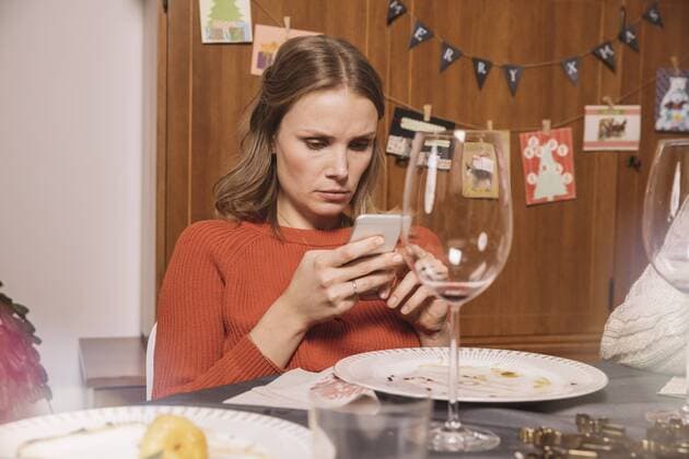 Woman playing with her smartphone after Christmas dinner model released Symbolfoto property released  MFF002858