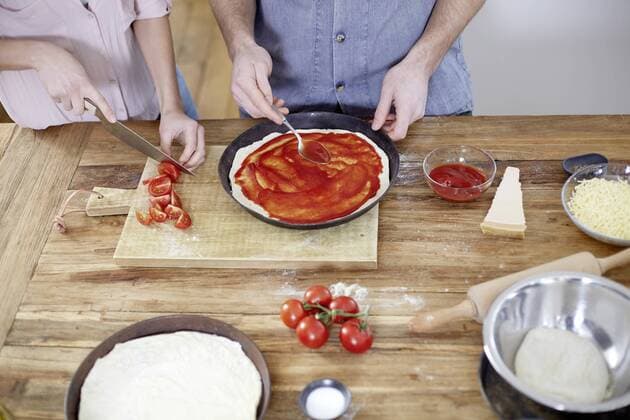 Couple preparing pizza in kitchen model released Symbolfoto property released  FMKF002373