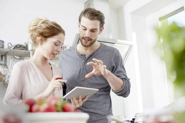 Couple looking at digital tablet in kitchen model released Symbolfoto property released  FMKF002378