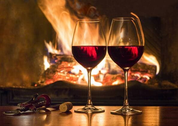 Two glasses of red wine in front of a fireplace property released  JAAF000336