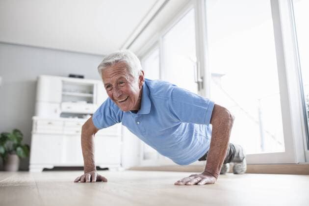Portrait of senior man doing pushups at home model released Symbolfoto property released  RBF004227