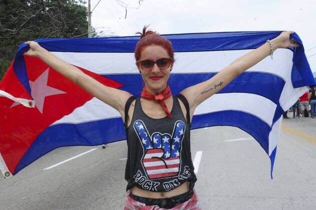 (160326) -- HAVANA, March 26, 2016 -- A woman poses with the Cuban national flag near the Sports City ahead of the free concert of British band The Rolling Stones, in Havana, Cuba, on March 25, 2016. Over half a million people are expected Friday at the Rolling Stones first ever concert in Cuba, a landmark cultural event that comes just three days after U.S. President Barack Obama visited the Caribbean nation. Paula Ribas ) CUBA-HAVANA-MUSIC-THE ROLLING STONES TELAM 