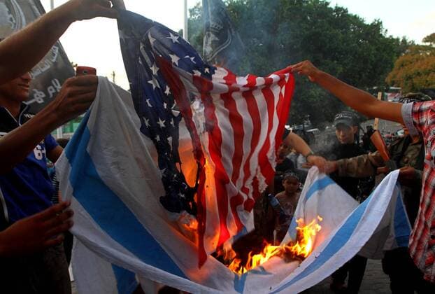 Sep. 29, 2011 - Gaza City, West Bank - Palestinian militants of Popular Resistance Committees burn an Israeli and American flags during a rally to mark the 11th anniversary of Al-Aqsa Intifada (uprising) in Gaza city. Israel on Tuesday approved construction of 1,100 homes for Jews on the annexed land in the West Bank, a move that could complicate international efforts to renew peace talks and defuse a crisis over a Palestinian statehood bid at the United Nations. - ZUMAap3_