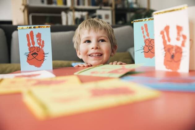 Happy little boy with self-made Easter cards at home model released Symbolfoto property released  MFF002957