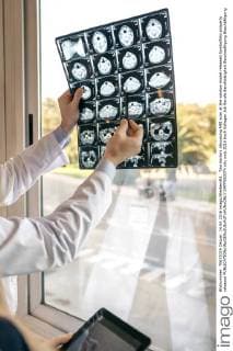 Two doctors discussing MRI scan at the window model released Symbolfoto property released  DAPF000074