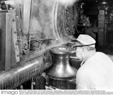 United States: c. 1950 A man with safety goggles working at a large industrial grinding machine. Underwood Archives The Image Works xUnderwoodxArchives 1-Work-Fact-Men_10