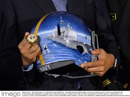 President Barack Obama holds a ring and a helmet given to him as he welcomes the United States Naval Academy Football Team to the White House to present them with the 2015 Commander-in-Chief?s Trophy, in Washington, D.C. on April 27, 2016. The Commander-in-Chief s Trophy is awarded to each season s winner of the American college football triangular series among the teams of the U.S. Military Academy, the U.S. Naval Academy, and U.S. Air Force Academy.  WAP20160427333 KEVINxDIETSCH