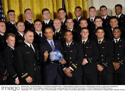 President Barack Obama looks at a championship ring as he poses with members of the United States Naval Academy Football Team after presenting them with the 2015 Commander-in-Chief?s Trophy, at the White House in Washington, D.C. on April 27, 2016. The Commander-in-Chief s Trophy is awarded to each season s winner of the American college football triangular series among the teams of the U.S. Military Academy, the U.S. Naval Academy, and U.S. Air Force Academy.  WAP20160427334 KEVINxDIETSCH
