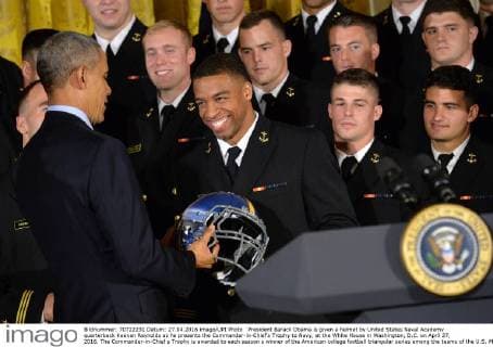 President Barack Obama is given a helmet by United States Naval Academy quarterback Keenan Reynolds as he presents the Commander-in-Chief?s Trophy to Navy, at the White House in Washington, D.C. on April 27, 2016. The Commander-in-Chief s Trophy is awarded to each season s winner of the American college football triangular series among the teams of the U.S. Military Academy, the U.S. Naval Academy, and U.S. Air Force Academy.  WAP20160427336 KEVINxDIETSCH
