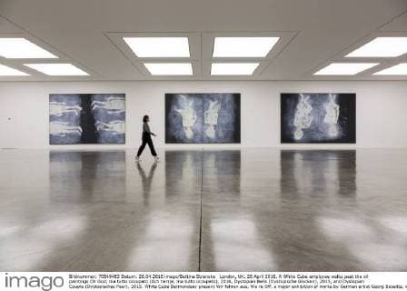 London, UK. 26 April 2016. A White Cube employee walks past the oil paintings Oh God, ma tutto occupato (Ach herrje, ma tutto occupato), 2016, Dystopian Bells (Dystopische Glocken), 2015, and Dystopian Couple (Dystopisches Paar), 2015. White Cube Bermondsey present Wir fahren aus, We re Off, a major exhibition of works by German artist Georg Baselitz, including new large-scale paintings, sculpture and works on paper. The exhibition runs from 27 April to 3 July 2016, entrance is free. Georg Baselitz, Wir fahren aus, White Cube, London, UK