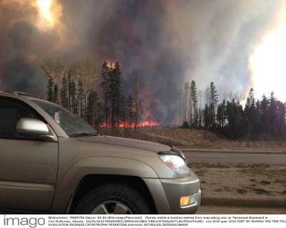 Flames visible a hundred metres from evacuating cars on Thickwood Boulevard in Fort McMurray, Alberta. 04 05 2016 PANORAMIC GREGHALINDA 