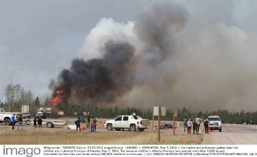 (160508) -- EDMONTON, May 7, 2016 -- Journalists and policemen gather near the wildfire site in Alberta Province of Canada, May 7, 2016. The massive wildfire in Alberta Province has covered more than 2,000 square kilometers by Saturday and forced almost 100,000 residents to evacuate. ) (lyi) CANADA-ALBERTA-WILDFIRE LixBaodong 