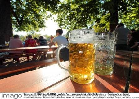 geleerte sowie halb gefüllte Maß Bier stehen am Muttertag auf einem Biertisch in der Abendsonne im Biergarten Königlicher Hirschgarten in München, Bayenr, Deutschland