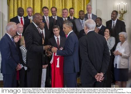 U.S. President Barack Obama receives a jersey from Thurl Bailey (L) after greeting former players and staff of the 1983 NCAA National Basketball Championship North Carolina State Wolfpack in the East Room of the White House in Washington, DC on May 9, 2016. The President and Vice President met briefly with members of the team and their families in the East Room. The team was previously unable to visit the White House to be recognized for their championship. Pool  WAX20160509102 SHAWNxTHEW