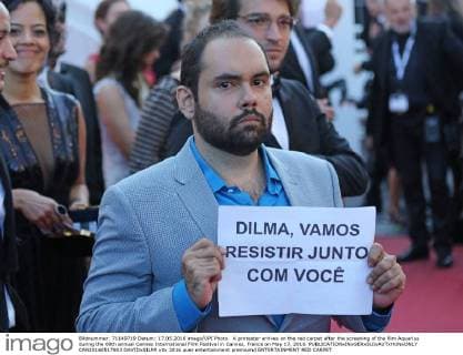 A protester arrives on the red carpet after the screening of the film Aquarius during the 69th annual Cannes International Film Festival in Cannes, France on May 17, 2016.  CAN20160517803 DAVIDxSILPA