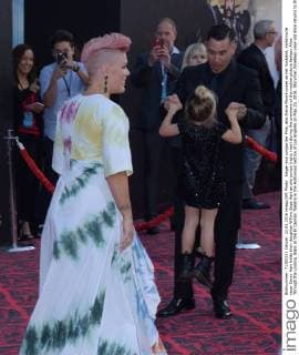 Singer and songwriter Pink, aka Alecia Moore poses as her husband, motorcycle racer Carey Hart holds their daughter Willow Sage Hart as she jumps (right, rear) during the premiere of the motion picture fantasy Alice Through the Looking Glass at the El Capitan Theatre in the Hollywood section of Los Angeles on May 23, 2016. Storyline: Nineteen-year-old Alice returns to the magical world from her childhood adventure, where she reunites with her old friends and learns of her true destiny: to end the Red Queen s reign of terror.  LAP2016052355 JIMxRUYMEN
