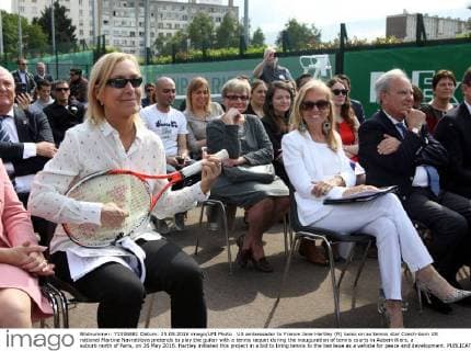 US ambassador to France Jane Hartley (R) looks on as tennis star Czech-born US national Martina Navratilova pretends to play the guitar with a tennis raquet during the inauguration of tennis courts in Aubervilliers, a suburb north of Paris, on 26 May 2016. Hartley initiated this project in a bid to bring tennis to the banlieue as a vehicle for peace and development.  PAR20160526103 MAYAxVIDON-WHITE