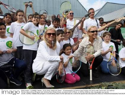 US ambassador to France Jane Hartley and tennis star Czech-born US national Martina Navratilova (R) pose with children from Aubervilliers, a suburb north of Paris, on 26 May 2016 as they inaugurate new tennis courts. Hartley initiated this project in a bid to bring tennis to the banlieue as a vehicle for peace and development.  PAR20160526105 MAYAxVIDON-WHITE