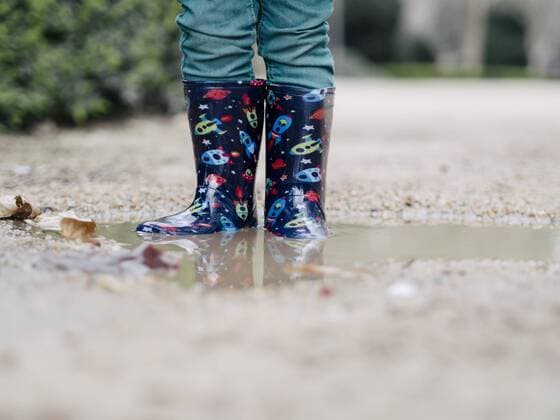 Little boy wearing Wellington boots standing in a puddle, partial view model released Symbolfoto  XCF000080
