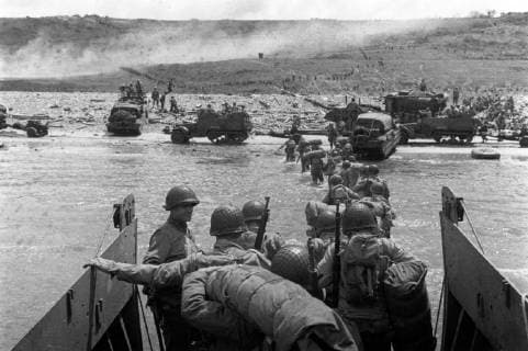 IMAGO History, Zweiter Weltkrieg: 1939 - 1945 Troops wade ashore from a LCVP landing craft, off Omaha Beach, on D-Day, June 6, 1944, during the Allied invasion of German-occupied France. Note DUKWs and half-tracks at the water line, lines of men headed inland, and M1903 and M1 rifles carried by some of the troops leaving the landing craft.  WAX2016060145 U.S.xArmyxSignalxCorps