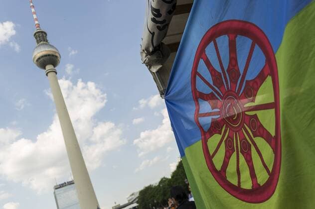 Eine Romflagge ist während der Roma Demonstration am 03.06.2016 in Berlin, Deutschland mit dem Fernsehturm im Hintergrund zu sehen. Ca 150 Roma und Aktivisten demonstrierten für ein Bleiberecht für alle Sinti und Roma.