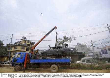 June 4, 2016 - Kathmandu, NP, Nepal - A Worker arranging crane to lift Smashed Card for dismantle using Oxygen Acetylene Gas to extract metal for making Iron Rods at Kathmandu, Nepal on June 04, 2016. Kathmandu Nepal  - ZUMAn230