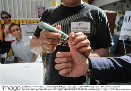 June 5, 2016 - Tijuana, Baja California, Mexico - June 5, 2016, Tijuana, Baja California, Mexico_ At a polling place in the middle class La Mesa neighborhood a polling worker marks the thumb of a voter so he won t be able to vote again today. Mandatory Photo Credit: Photo by Tijuana Mexico - ZUMAs44_
