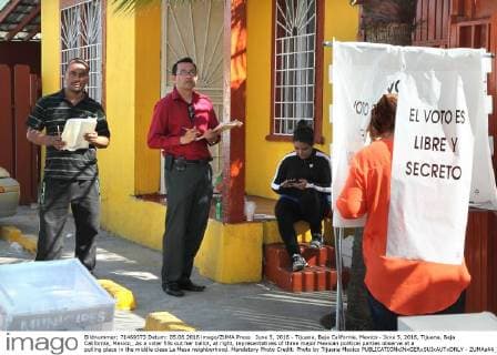 June 5, 2016 - Tijuana, Baja California, Mexico - June 5, 2016, Tijuana, Baja California, Mexico_ As a voter fills out her ballot, at right, representatives of three major Mexican political parties observe at a polling place in the middle class La Mesa neighborhood. Mandatory Photo Credit: Photo by Tijuana Mexico - ZUMAs44_
