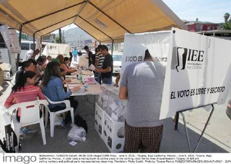 June 5, 2016 - Tijuana, Baja California, Mexico - June 5, 2016, Tijuana, Baja California, Mexico_ A voter uses a voting booth at polling place in the working class Florido area of southeastern Tijuana. At left are polling workers and political party representatives observing. Mandatory Photo Credit: Photo by Tijuana Mexico - ZUMAs44_