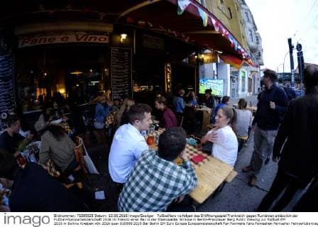 Fußballfans verfolgen das Eröffnungsspiel Frankreich gegen Rumänien anlässlich der Fußball-Europameisterschaft 2016 im Freisitz einer Bar in der Eberswalder Strasse in Berlin-Prenzlauer Berg Public Viewing zur Fußball EM 2016 in Berlins Kneipen