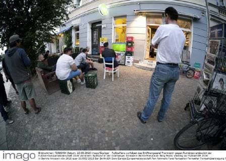 Fußballfans verfolgen das Eröffnungsspiel Frankreich gegen Rumänien anlässlich der Fußball-Europameisterschaft 2016 vor einem Spätkauf in der Oderberger Strasse in Berlin-Prenzlauer Berg Public Viewing zur Fußball EM 2016 in Berlins Kneipen