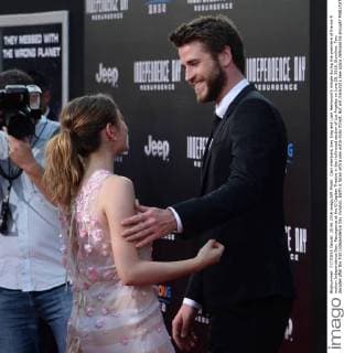 Cast members Joey King and Liam Hemsworth mingle during the premiere of the sci-fi motion Independence Day: Resurgence at the El Capitan Theatre in the Hollywood section of Los Angeles on June 20, 2016. Storyline: Two decades after the first Independence Day invasion, Earth is faced with a new extra-Solar threat. But will mankind s new space defenses be enough?  LAP2016062050 JIMxRUYMEN