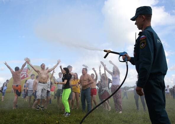 TVER REGION, RUSSIA - JULY 9, 2016: An employee of the Russian Emergency Situations Ministry sprays participants in the 16th Nashestvie (Invasion) rock music festival in the village of Bolshoye Zavidovo with water. Alexander Ryumin TASS  TS029709