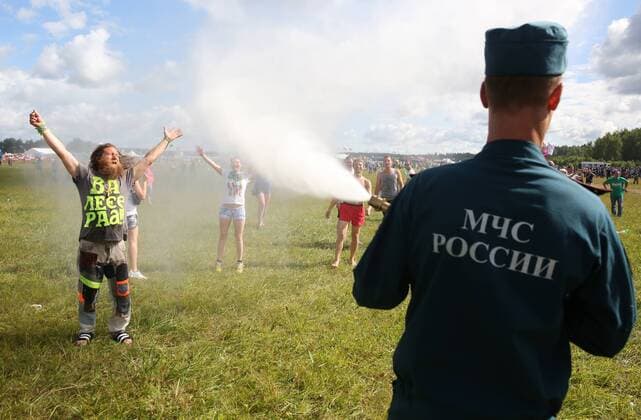 TVER REGION, RUSSIA - JULY 9, 2016: An employee of the Russian Emergency Situations Ministry sprays participants in the 16th Nashestvie (Invasion) rock music festival in the village of Bolshoye Zavidovo with water. Alexander Ryumin TASS  TS02970E