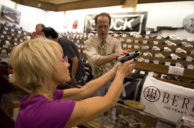 Oct. 2, 2010 - Kennesaw, GA, USA - Kyla Rayne tries out a new Argentinian Bersa handgun with assistance of Erik Fredrick at Nick s Gun and Tackle Shop. Women account for thirty per cent of the stores business, sales figures show. - ZUMAn03_