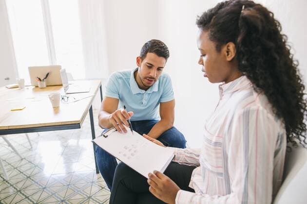 Young businessman and woman discussing papers in office model released Symbolfoto property released  EBSF001537