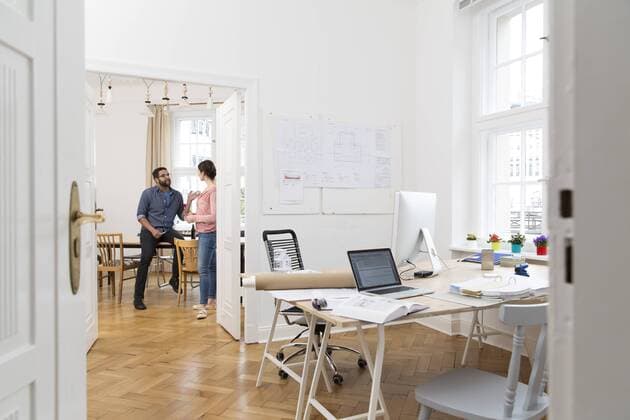 Two creative professionals talking in office model released Symbolfoto property released  FKF001842