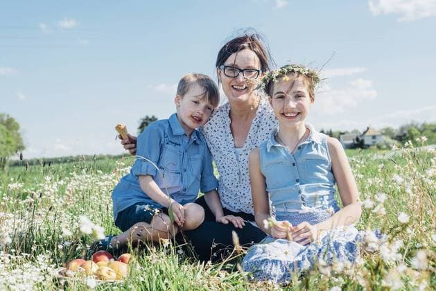 Mother and two children relaxing in meadow model released Symbolfoto  MJF001957