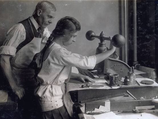 Photographic print of a 15 year old girl at embossing machine in the embossing shop of Harry C. Taylor, 61 Court Street. Location, Boston, Massachusetts. Photographer Lewis Wickes Hine (1874-1940). WorldxHistoryxArchive