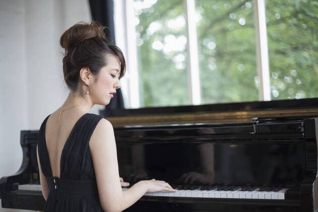 Young woman playing on a grand piano in a rehearsal studio. Young woman playing on a grand piano in a rehearsal studio.  21471