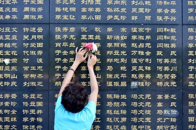 (160728) -- TANGSHAN, July 28, 2016 -- A woman pastes flowers beside the name of her relative killed in the 1976 Tangshan earthquake listed on a memorial wall in Tangshan, north China s Hebei Province, July 28, 2016. Local residents came to the Tangshan Earthquake Ruins Memorial Park on Thursday to mark the 40th anniversary of the devastating earthquake that killed their family members and friends. )(wsw) CHINA-HEBEI-TANGSHAN-EARTHQUAKE-COMMEMORATION (CN) MouxYu 