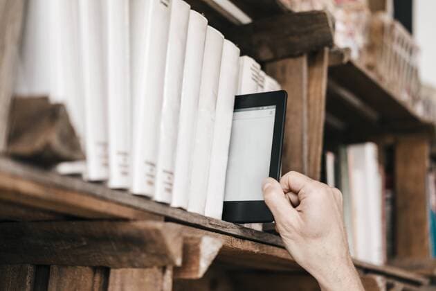 Hand taking e-book from book shelf model released Symbolfoto property released  KNSF000055