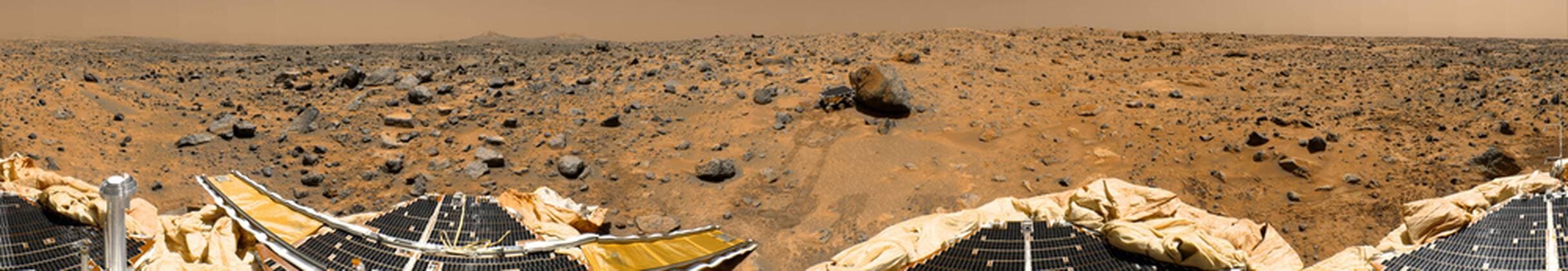 November 4, 1997 - This is a geometrically improved, color enhanced version of the 360-degree panorama heretofore known as the Gallery Pan, the first contiguous, uniform panorama taken by the Imager for Mars Pathfinder (IMP) over the course of Sols 8, 9, and 10. Different regions were imaged at different times over the three Martian days to acquire consistent lighting and shadow conditions for all areas of the panorama. At left is a Lander petal and a metallic mast which is a portion of the low-gain antenna. Misregistration in the antenna and other Lander features is due to parallax in the extreme foreground. On the horizon the double Twin Peaks are visible, about 1-2 kilometers away. The rock Couch is the dark, curved rock at right of Twin Peaks. Another Lander petal is at left-center, showing the fully deployed forward ramp at far left, and rear ramp at right, which rover Sojourner us Copyright: StocktrekxImages stk202209s