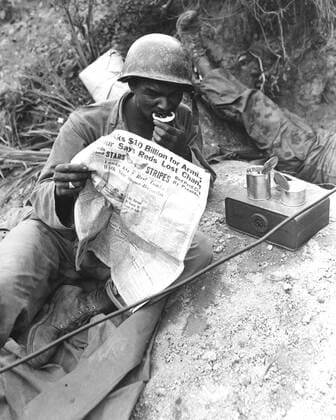 August 9, 1950 - U.S. soldier reads the latest news while enjoying chow during lull in battle against the Communist led North Korean invaders, somewhere in Korea.  Copyright: StocktrekxImages stk107050m