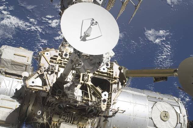 An astronaut (partially obscured by Ku-band antenna), participates in a session of extravehicular activity as construction and maintenance continue on the International Space Station. During the spacewalk, astronauts loosened bolts holding six replacement batteries, installed a second antenna for high-speed Ku-band transmissions and added a spare parts platform to Dextre, a two-armed extension for the station s robotic arm.  Copyright: StocktrekxImages stk203325s