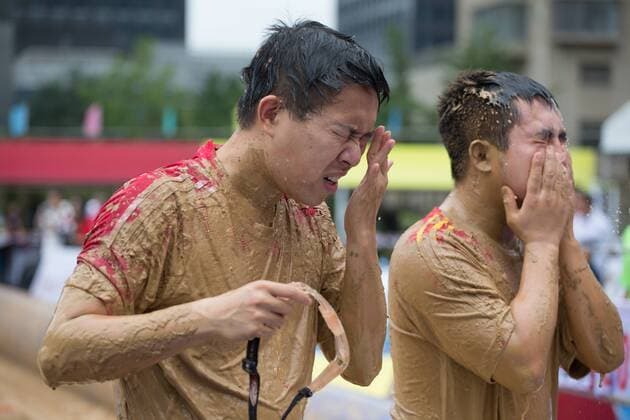Schlammfußball in Peking BEIJING, CHINA - AUGUST 13: Two players wipe sweat during the first station match of 2016 Swamp Soccer China tournament at Yuetan Park on August 13, 2016 in Beijing, China. Different from former years matches in China, there were four teams composed entirely of women this year. The Swamp Soccer World Cup features a team of extreme football players that play in bogs or swamps. This sport is said to have originated in Finland, with the aim of helping athletes and soldiers exercise, due to the physical demands of the sport.  CFP490208064