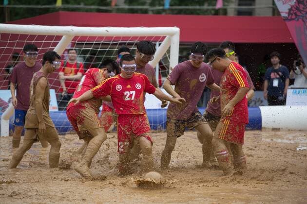 Schlammfußball in Peking BEIJING, CHINA - AUGUST 13: Players battle for the ball during the first station match of 2016 Swamp Soccer China tournament at Yuetan Park on August 13, 2016 in Beijing, China. Different from former years matches in China, there were four teams composed entirely of women this year. The Swamp Soccer World Cup features a team of extreme football players that play in bogs or swamps. This sport is said to have originated in Finland, with the aim of helping athletes and soldiers exercise, due to the physical demands of the sport.  CFP490208065