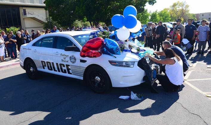 New Mexico: Trauerfeier für getöteten Polizisten August 21, 2016 - Las Cruces, NEW MEXICO, U.S. - 082116.Hatch Volunteer firefighter Manny Contreras ,<cq., and his wife Yvette Contreras ,<cq>,pause fro a moment of prayer in front of Police Officer Jose Chavez,<cq>. cruiser at his funeral at the Pan Am Center. Chavez was killed last week while conducting a traffic stop .Photographed on Sunday August 21, 2016. JOURNAL. Las Cruces U.S. - ZUMAab1_