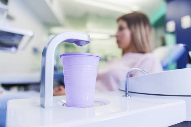 Water tap with plastic cup in dental surgery model released Symbolfoto property released  ZEDF000242